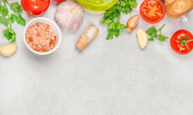 Mutfak tezgahında domates, sarımsak, maydanoz, tuz, soğan, biber ve zeytinyağı pişirmek için taze malzemeler hazır. Üst Manzara. Boşluğu kopyala.