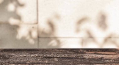 Yumuşak yaprak gölgeleri, sade ahşap bir masanın arkasındaki fayanslı duvara düşer. Sakin ve güneşli bir atmosfer yaratır. Sessiz anlar için mükemmel bir ortam.