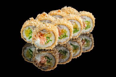 Somon, sebze ve kremalı peynirle dolu canlı bir suşi seti altın ekmek kırıntılarıyla kaplanır ve parlak siyah yansıtıcı bir yüzey üzerinde sunulur..