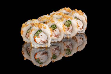 Karides, krem peynir, salatalık ve çıtır çıtır soslarla dolu suşi ruloları düzgün bir şekilde düzenlenir ve parlak siyah bir yüzeye yansıtılır..