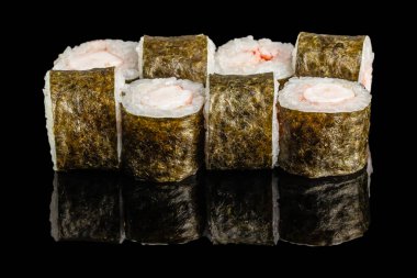 Deniz yosunu ve pirince sarılı sade karides maki dürümleri parlak siyah yansıtıcı bir yüzeye güzelce yerleştirilmiştir..