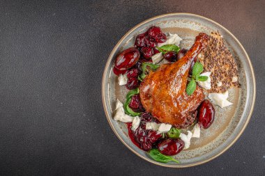Bir gurme ördek bacağı konfeti kızarmış kiraz, krem peynir, taze yeşillikler ve sofistike ve lezzetli bir yemek için gevrek keten tohumu krakeri ile kaplıdır..