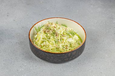 Kırsal seramik kasede servis edilen taze lahana salatası, dereotu, ayçiçeği tohumu ve hafif sos..