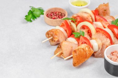 Soğan ve domatesli çiğ tavuk şişleri. Baharatlı ve ızgara için hazır..