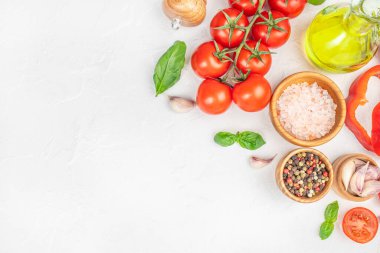 Beyaz zemin üzerinde domates, sarımsak, bitki, baharat ve yağ içeren taze malzemeler..
