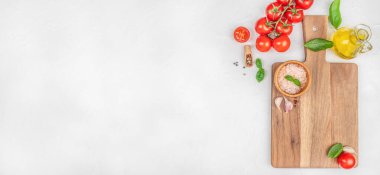 Beyaz arka planda domatesli, sarımsaklı, tuzlu, fesleğenli ve zeytinyağlı taze yemek malzemeleri. Uzun afiş biçimi. Üst Manzara. Boşluğu kopyala