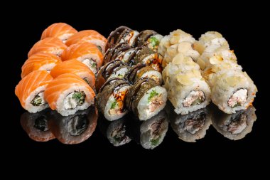 Somon, yosun ve badem kaplı çeşitleri içeren çeşitli suşi dürümleri parlak siyah arka planda sıralanmış..