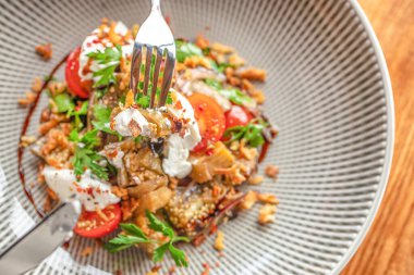 Taze otlu ızgara patlıcan salatası, kiraz domatesleri, kremalı yoğurt ve dokulu seramik kasede servis edilen çıtır çıtır soslar. Üst Manzara. Boşluğu kopyala.
