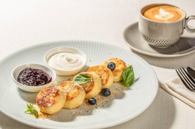 Geleneksel peynirli krep yanında ekşi krema ve bir fincan kapuçino ile servis edilir. Boşluğu kopyala.