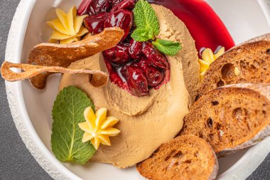 Üzerine vişne ezmesi, nane yağı ve çıtır kraker konmuş kremalı ciğer ezmesi..