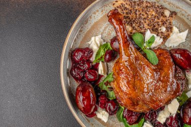 Kavrulmuş ördek bacağı seramik tabakta vişne ezmesi, krem peynir, roka ve çıtır tohum krakeri. Üst Manzara. Boşluğu kopyala.