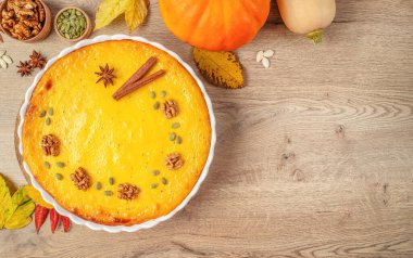 Şükran Günü kutlamaları için ceviz, tohum ve baharatla süslenmiş ev yapımı balkabağı turtası. Üst Manzara. Boşluğu kopyala.