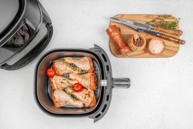 Çiğ salamura edilmiş tavuk budu, sebzeli ve domatesli fırın sepeti pişirmeye hazır. Üst Manzara. Boşluğu kopyala.