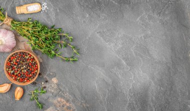 Taze otlar, sarımsaklı biber ve koyu taş zemin üzerinde deniz tuzu. Üst Manzara. Boşluğu kopyala.