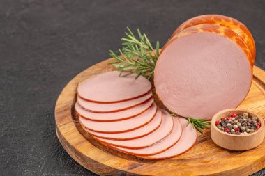 Ahşap tahtada biberiye ve biberiyeyle dilimlenmiş füme sosis. Üst Manzara. Boşluğu kopyala.