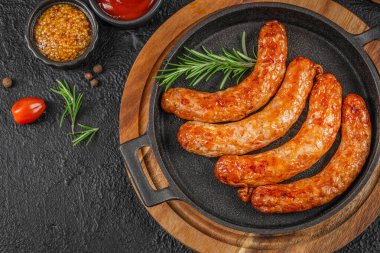 Biberiye hardallı ızgara domuz sosisi ve rustik tavada ketçap. Boşluğu kopyala, üst görünüm.