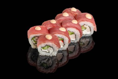 Krem peynirli, salatalıklı ve siyah arka planda baharatlı mayonezli ton balıklı suşi ruloları..