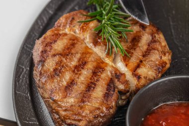 Biberiyeli biftek ve siyah tabakta sos yakın..