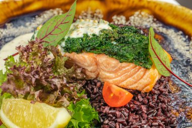 Ispanak soslu ızgara somon filetosu, siyah pirinç, limon ve taze salata..