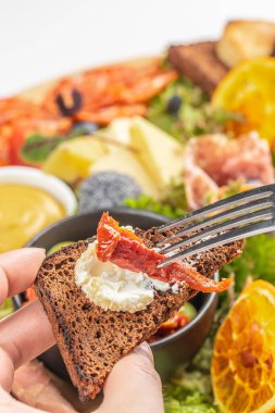 Çavdar ekmeği bruschetta 'yı keçi peyniri ve kurutulmuş domatesle kapat..