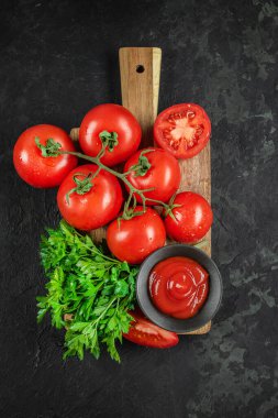 Maydanozlu olgun domates manzarası ve arka planda bir kase ketçap..