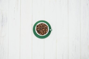 green coffee beans in a bowl on a wooden background. top view. copy space.