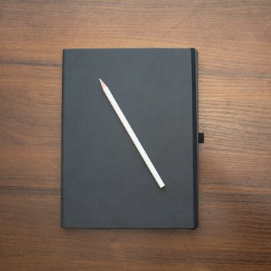 A beautiful pencil lies on a large notebook