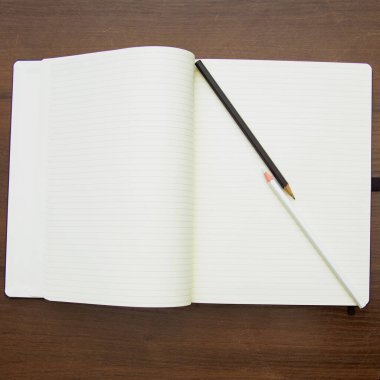 A beautiful pencil lies on a large notebook