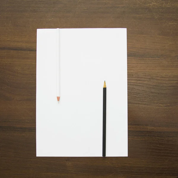 木の背景に白い紙と鉛筆 モックアップ トップビュー — ストック写真