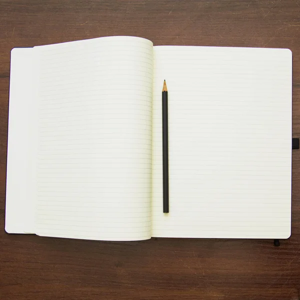 空白のノートブックとペンを木製の背景に — ストック写真
