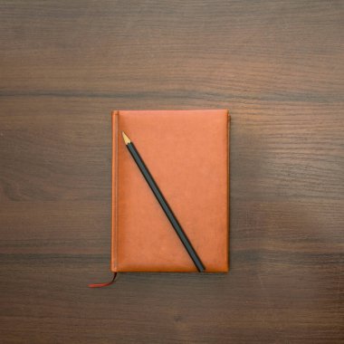 Bir fotoğraf stüdyosundaki arka planda güzel bir defter ve kalem.