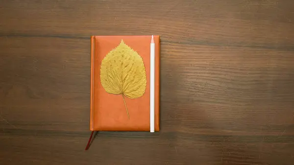 木制桌子 有一本书 红色围巾 褐色背景 — 图库照片