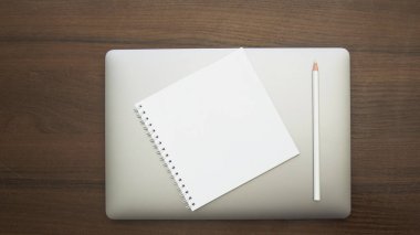 blank notepad with pen and pencil on wooden background