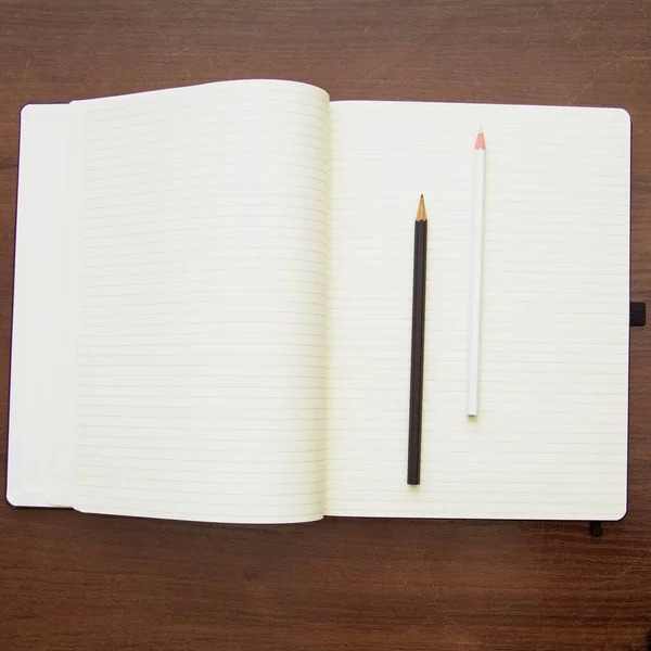 鉛筆と木製のテーブルの上のペンで空のノートブック — ストック写真