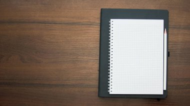 defter ve kalem ahşap masaya