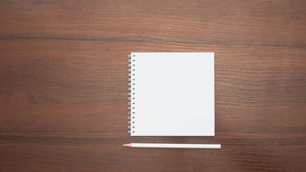木製の背景に鉛筆で空白のメモ帳 — ストック写真