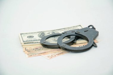 Kelepçe ve para beyaz arka planda