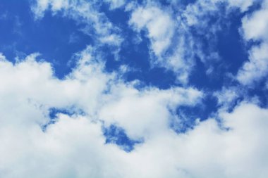 Mavi gökyüzüne karşı beyaz kabarık bulutlar, metin için kopyalama alanı olan doğal arkaplan.