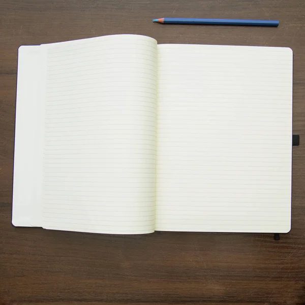 木制背景的空白笔记本和铅笔 — 图库照片