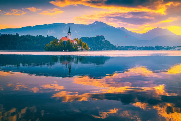 Stunning travel destination in Slovenia. Majestic sunrise with colorful clouds and hot air ballon over the lake Bled, Bled, Slovenia, Europe
