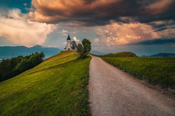 尾根上のかわいい小さな教会と農村風景 日没の暗い雲と聖プリモス教会 ヤムニク村 スロベニア ヨーロッパ — ストック写真