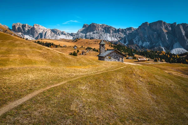 山の牧草地とバックグラウンドの壮大な山の尾根の小さな石のチャペル プエズオドル山グループ ドロマイト イタリア ヨーロッパ — ストック写真