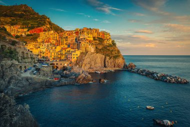 Manarola, Cinque Terre, Liguria, İtalya ve Avrupa 'da gün batımında kayalıklarda renkli deniz kenarındaki evleri ile dünyanın en ünlü ve ziyaret edilen turistik köylerinden biri.