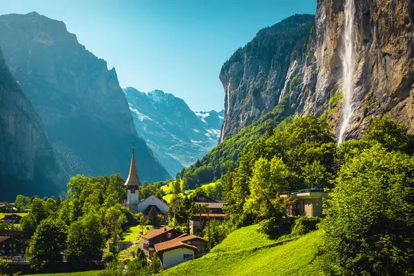 Lauterbrunnen Vadisi 'nin en çok ziyaret edilen dağlık köylerinden biri. Arka planda şaşırtıcı yüksek kayalıklar ve şelaleler, Lauterbrunnen, Bernese Oberland, İsviçre, Avrupa