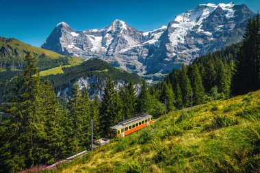 Grutschalp ve Murren arasındaki elektrikli kırmızı turist treni. Arka planda çarpıcı yüksek karlı dağlar, Lauterbrunnen vadisi, Bernese Oberland, İsviçre, Avrupa