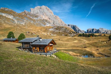 Şirin ahşap evler ve dağdaki güzel alp gölü, Puez-Odle dağ grubu, Dolomitler, İtalya, Avrupa