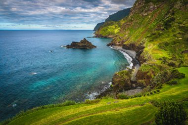 Atlantik Okyanusu 'nda renkli kayalar ve kıyılarda muhteşem yeşil dik yamaçlar bulunan Madeira Adası, Portekiz, Avrupa
