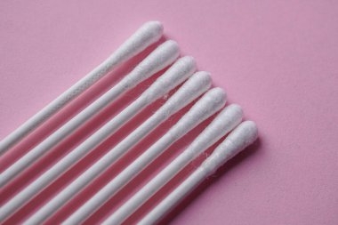 Pembe arka planda pamuk örnekleri, kozmetik ve hijyenik ürün 