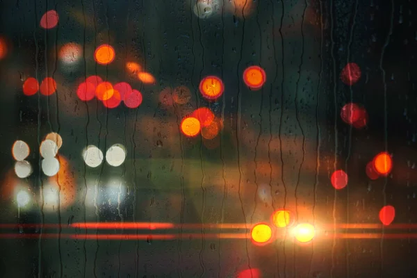 雨天窗上的雨滴和街灯的背景 — 图库照片
