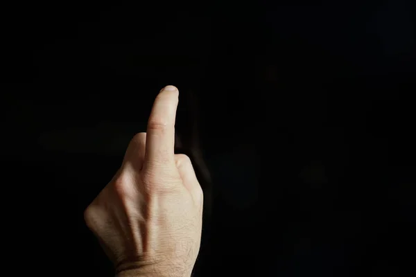 index finger pointing at the screen, black background